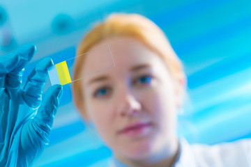 Canvas Print - scientist woman holding microscope slide