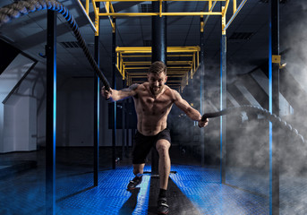 Wall Mural - Man working out with battle ropes at gym