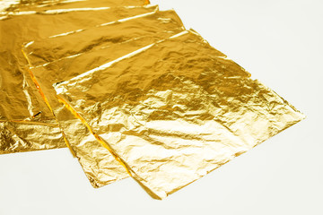 Pile of square gold leaf on white background