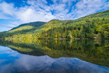 Wall Mural - Incredible reflection of the forest and mountains in the huge lake. Silver Lake Park, Mount Baker area, USA