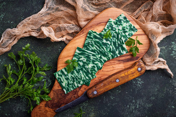 Green sliced cheese with herbs. 