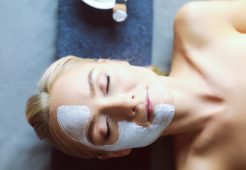 Face mask.Beautiful young girl at spa ,cosmetician woman applying facial mask