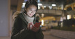 © leungchopan - Business woman using mobile phone at night