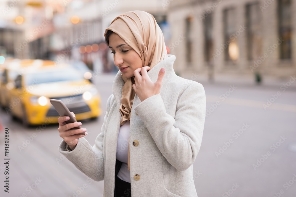 Woman in hijab using mobile phone Stock Photo | Adobe Stock