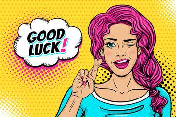 Wall Mural - Pop art female face. Sexy young woman winks with pink hair and open smile, crossed fingers for luck symbol and Good Luck speech bubble on halftone. Vector colorful illustration in retro comic style.
