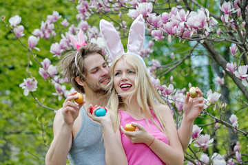 Wall Mural - girl and man with bunny ears holding colorful eggs