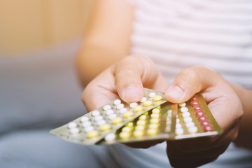 Close up  hand contraceptive pill on with colorful pills strips. Contraception reduces childbirth and pregnant concept.