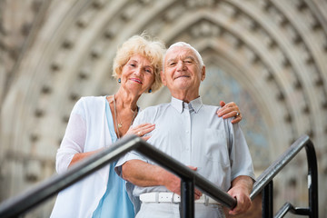 Wall Mural - Senior couple standing near iron railings in front of cathedral