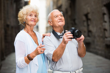 Wall Mural - Mature couple on traveling together, photographing city attractions with camera