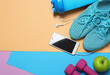 © Africa Studio - Gym stuff, mobile phone and blank space for exercise plan on color background. Flat lay composition