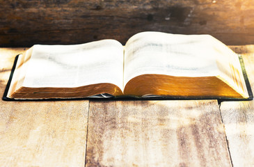 Wall Mural - The opened bible on  wooden  table against the light from above, christian education concept background  with copy space