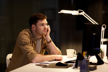 tired or bored man on table at night office