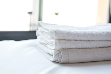 Place a towel on the bed in the hotel.