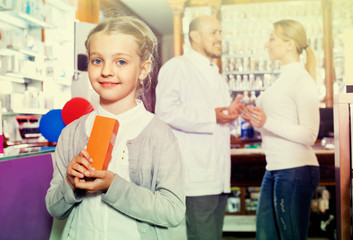 Wall Mural - Little glad girl  in the pharmacy with parents and pharmacist