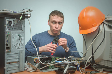 Crazy Computer network technician man is crimping a network cable by crimper tool in his hands.