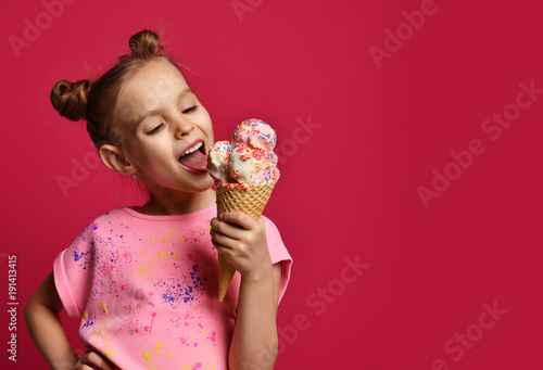 Fotografía Pretty baby girl kid eating licking big ice cream in waffles cone with raspberry