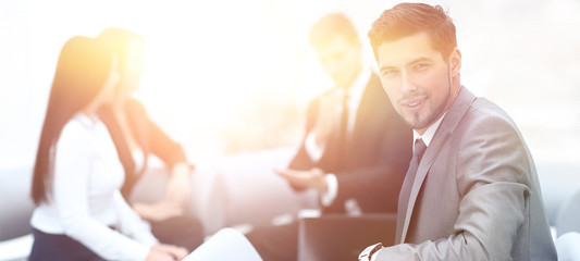 Canvas Print - businessman sitting in an office on the background of business team.