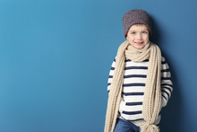 Cute Little Boy In Warm Clothing On Color Background. Ready For Winter Vacation