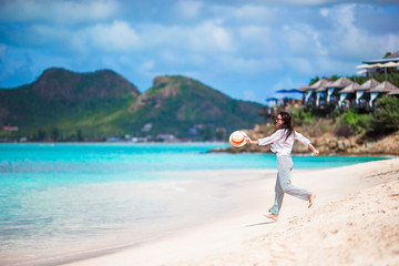 Wall Mural - Young beautiful woman having fun on tropical seashore. Happy girl walking at white sand tropical beach
