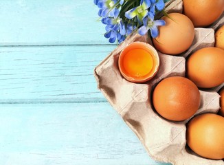 Yellow yolk, The eggs are beautifully arranged on eggshell decorated with flowers placed on a blue wooden background, delicious cook