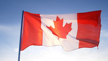 Canada Flag On Clear Blue Sky
