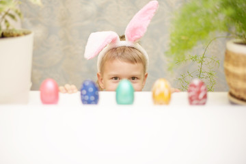 little boy with easter bunny ears and eggs