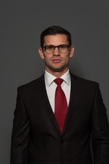 Wall Mural - Portrait of successful confident businessman looking at the camera against gray background