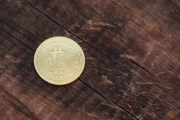 Golden bitcoin coin on wooden background, copyspace