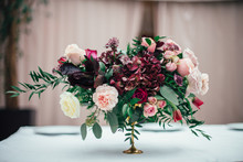 Rich Bouquet Of Red, Pink And White Roses And Greenery Stands On The Table In A Luxury Restaurant