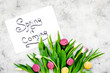 © 9dreamstudio - Spring is coming hand lettering near delicate tulips on grey background top view copy space
