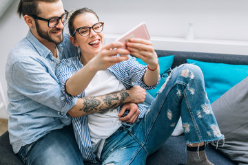 Wall Mural - Young couple taking selfie at home 