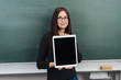 © contrastwerkstatt - Young woman holding digital tablet in classroom