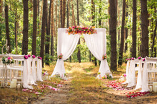 Beautiful Romantic Festive Place Made With Wooden Square And Floral Roses Decorations For Outside Wedding Ceremony In Green Park. Wedding Settings At Scenic Place. Horizontal Color Photography.
