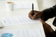 © fizkes - African american businessman agree to make deal signing business contract concept, black man hand putting signature on commercial business paper, filling legal document at work, close up view