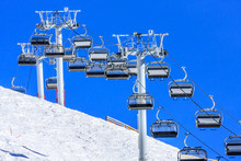 All Vacant Are The Chairs Of Cableway Ski Lift Line In Gorky Gorod Mountain Ski Resort In Sochi, Russia, Viewed Against Blue Sky And White Snow On Sunny Winter Day