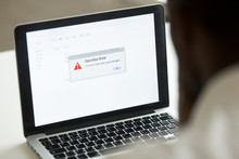 Computer Error Failure Concept, African Man Using Laptop With Application Failure Message On Screen, Bad Software Pc App Crash, Email Malware, Data Loss And Recovery, Rear View Over The Shoulder