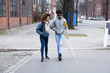 Woman Helping Blind Man While Crossing Road