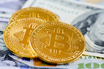 golden bitcoin coins on us dollars notes