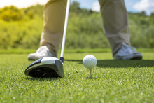 Golfer Put Golf Ball On Tee Preparing Shot On To Golf Hole