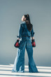 © LIGHTFIELD STUDIOS - rear view of stylish girl in denim clothes and boxing gloves