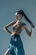 © LIGHTFIELD STUDIOS - fashionable model posing in sunglasses with ponytail hairstyle, isolated on grey