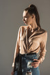 © LIGHTFIELD STUDIOS - beautiful girl with ponytail hairstyle posing in blouse, isolated on grey