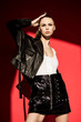 © LIGHTFIELD STUDIOS - attractive girl posing in trendy leather jacket for fashion shoot on red