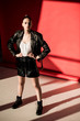© LIGHTFIELD STUDIOS - fashionable model posing in black leather jacket on red