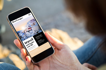 Canvas Print - woman sitting in the street holding her smartphone to travel online