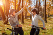 © Aleksey - Happy young couple having fun riding a bicycle on sunny autumn day in the park. Caught in the backlight.
