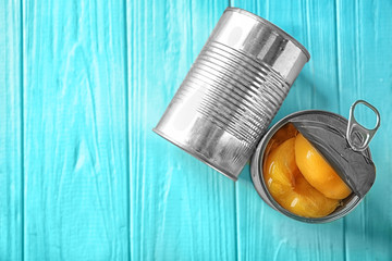 Poster - Cans with pickled apricots on wooden background