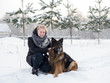 © pavelkant - Woman playing with dog in winter