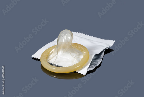 Fotomural Contraception - condom on torn packaging on a gray background.