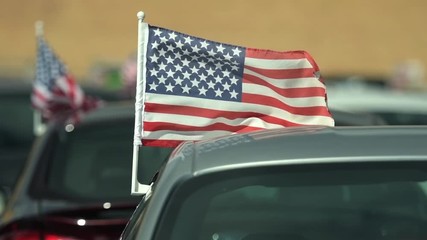 Wall Mural - American Made Cars Sale Concept Photo. Brand New Vehicles For Sale with American Flags Attached. Slow Motion Footage